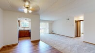 Located at 456 Jeanne Ct in Wood Dale, Illinois, this single-floor residence offers a well-organized layout with a cohesive blend of hardwood flooring and plush carpeting throughout. The open-concept living and dining area is generously sized, featuring neutral white walls, a ceiling fan with integrated lighting, and large vertical-blind-covered sliding doors that invite natural light and provide outdoor views. The transition between the wood-floored entry and carpeted living space creates a natural division within the open floor plan.

The kitchen is well-appointed with warm-toned wood cabinetry, granite countertops, a double-basin sink beneath a window, and a full suite of stainless steel appliances including a gas range, dishwasher, and refrigerator. Hardwood flooring extends through the kitchen, complementing the cabinetry tones.

The bedrooms are carpeted and receive natural light through standard windows. One bedroom features a spacious walk-in closet with built-in hanging rods, offering practical storage. The bathrooms are finished with granite vanity tops, wood cabinetry, and tiled tub-shower surrounds with decorative accent tile, providing a clean and updated aesthetic throughout.