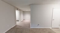 Located at 1500 Willow Trail Drive in Norcross, Georgia, this one-bedroom, one-bathroom residence offers a thoughtfully organized single-floor layout. The living area is finished with wall-to-wall carpet and neutral gray walls, creating a clean, versatile backdrop. Large windows and a sliding glass door with vertical blinds invite abundant natural light and provide views of surrounding greenery, while a separate exterior door offers additional outdoor access.

The kitchen is efficiently designed with gray shaker-style cabinetry, marble-look countertops, a white subway tile backsplash, wood-look luxury vinyl flooring, and stainless steel appliances including a refrigerator and range. A hallway connects the main living areas to the private quarters, featuring a separate laundry access point and HVAC venting.

The spacious bedroom is carpeted and bright, comfortably accommodating a full furniture arrangement. It includes a generous walk-in closet equipped with dual wire shelving systems on multiple walls, providing ample storage. The full bathroom features a tiled tub-shower combination, wood-look flooring, and a clean, functional layout. Textured ceilings are consistent throughout the residence, adding a classic finishing touch to this well-maintained home.