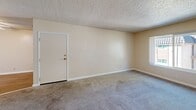 Located at 1424 Alamo Dr in Vacaville, California, this single-story, 3-bedroom, 2-bathroom home offers a functional and comfortable layout. The interior is finished with warm neutral tones throughout, and textured ceilings add a classic character to the living spaces. The living room is generously sized with soft carpeting and multiple vents for climate control, flowing into a combined kitchen and dining area that includes a pantry for added storage convenience. A utility room provides practical additional space. Each of the three bedrooms features plush carpeting, ceiling fans with light fixtures, and windows that invite natural light and outdoor views of surrounding greenery. The bedrooms are well-equipped with mirrored sliding closet doors that enhance the sense of space. The primary bedroom offers a comfortable footprint with ample closet storage. The two bathrooms are cleanly appointed — one features wood-look flooring, a white vanity with a medicine cabinet mirror, and a glass-enclosed shower stall with tile surround. A hallway connects the rooms efficiently, and four closets throughout the home provide excellent storage capacity. This home presents a practical, well-organized floor plan suited for everyday living.