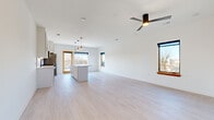 Located at 720 E 36th St in Charlotte, NC, this single-story home offers a clean, contemporary design with a bright, cohesive aesthetic throughout. The open-concept kitchen and living area serves as the heart of the home, featuring light wood-look flooring, crisp white walls, and multiple windows with warm wood trim that invite abundant natural light. The kitchen is well-appointed with white shaker-style cabinetry, a large central island with a white countertop, stainless steel appliances including a refrigerator, range, and microwave, and stylish pendant lighting overhead. The open layout flows seamlessly into the living area, which is equipped with a modern ceiling fan.

A wide hallway connects the main living space to three bedrooms, each featuring ceiling fans, light flooring, and windows framing outdoor views. The primary bedroom offers a comfortable footprint with dual windows. Both bathrooms are finished with large-format tile flooring, white vanities with matte black hardware, and glass-enclosed walk-in showers adorned with marble-look tile, creating a sleek, spa-like atmosphere. The overall design is modern and minimalist, with consistent finishes creating a polished, unified feel throughout.