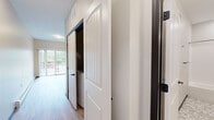 Located at 415 Hickory Dr in Cannon Falls, MN, this studio unit offers a thoughtfully designed single-floor layout that maximizes every square foot of living space. The open-concept kitchen and dining area serves as the heart of the unit, showcasing rich dark-toned cabinetry, granite-look countertops, and a full suite of stainless steel appliances including a refrigerator, range, and microwave. Pendant lighting above the kitchen peninsula adds a stylish, modern touch, while light hardwood-style flooring flows seamlessly throughout, brightening the space and creating a cohesive aesthetic. Natural light fills the area through well-placed windows and a sliding door that opens to a private balcony overlooking lush greenery — a standout feature that enhances the unit's connection to the outdoors. The hallway leads to a clean, well-finished full bathroom featuring a tub/shower combo with chrome fixtures, a granite-topped vanity with dark wood cabinetry, and penny-tile flooring that adds a refined detail. White panel doors with matte black hardware add a contemporary farmhouse touch throughout. The neutral color palette and clean lines give the space a fresh, modern ambiance that is both functional and inviting.