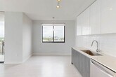 Located at 150 S Bryan Rd in Dania Beach, Florida, this three-bedroom, two-bathroom residence offers a well-designed single-floor layout with a clean, contemporary aesthetic throughout. Light wood-style flooring flows seamlessly across all rooms, complemented by crisp white walls and modern finishes that create a bright, airy atmosphere.

The kitchen is a standout feature, showcasing high-gloss white upper cabinetry, wood-toned lower cabinets, a subway tile backsplash, light quartz countertops, and a full suite of stainless steel appliances including a range, microwave, dishwasher, and French door refrigerator. Track lighting overhead adds a modern touch. The kitchen opens directly to a hallway and living area, promoting an open, connected feel.

Each of the three bedrooms is well-proportioned and filled with natural light through large windows framing expansive views of the Dania Beach skyline and lush treetops. The bedrooms feature double-door closets with sleek black hardware, adding a refined contrast to the otherwise all-white palette.

The two bathrooms are finished with neutral tile, modern vanities with wood-toned cabinetry, and a tub-shower combination with tile surround. Clean lines and recessed lighting maintain the contemporary feel throughout. Two hallways connect the rooms efficiently, and a dedicated closet provides additional storage.