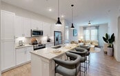 Located at 526 Vistera Blvd in Venice, FL, this 2-bedroom, 2-bathroom single-story residence offers a well-designed open-concept floor plan with a clean, contemporary aesthetic throughout. Light wood-style flooring flows seamlessly across the main living areas, complementing the neutral palette of soft whites and warm grays.

The heart of the home is a modern kitchen outfitted with white shaker cabinetry, stainless steel appliances, a subway tile backsplash, and a spacious center island with a undermount sink and pendant lighting overhead — ideal for dining and entertaining. The kitchen opens directly to both the dining area and a bright living room featuring a ceiling fan, large windows with natural light, and access to a private patio.

The primary bedroom is generously sized with plush carpeting and ample closet space. The two full bathrooms are finished with quartz countertops, modern vanity lighting, and wood-look tile flooring. Four closets provide exceptional storage throughout the unit. A dedicated laundry area adds everyday convenience.

With recessed lighting, ceiling fans, and large windows inviting Florida's natural light indoors, this thoughtfully designed residence delivers a comfortable and functional living experience in the heart of Venice.