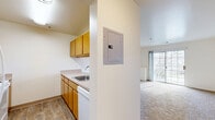 Located at 5711 Castlebridge Rd in Fredericksburg, VA, this 2-bedroom, 1-bathroom residence offers a practical and comfortable single-floor layout. The open-concept living and kitchen area forms the heart of the home, with the kitchen featuring warm oak-toned cabinetry, white appliances including a refrigerator and dishwasher, a sink, and durable wood-look flooring that provides easy maintenance. A pass-through opening connects the kitchen to the carpeted living room, which is bright and spacious, benefiting from a sliding glass door that opens to a private balcony with outdoor views and fills the room with natural light. The primary bedroom is generously sized, offering plush carpet, a large window, and access to a walk-in closet outfitted with wire shelving for ample storage. The second bedroom also features soft carpet and a double-door closet. A third closet provides additional storage within the unit. The full bathroom includes a wood-look tile floor, an oak-toned vanity with sink, a lighted mirror, and a toilet. Throughout, neutral wall tones and clean lines create a bright, move-in-ready atmosphere suited for comfortable everyday living.