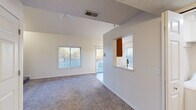 Located in Grandville, Michigan, this two-story home offers 2 bedrooms and 2 bathrooms across two well-proportioned floors. The main level is the larger of the two, featuring an open living area with vaulted ceilings, a ceiling fan, and plush carpeting. Abundant natural light flows in through multiple windows, and a sliding glass door leads directly to an outdoor deck overlooking colorful surroundings. The kitchen is efficiently designed with warm oak cabinetry, light countertops, a double sink, and stainless steel appliances including a range, over-the-range microwave, and refrigerator. Durable wood-look flooring runs throughout the kitchen. Both bathrooms are finished with wood-look flooring, oak vanities, and full tub/shower combos with chrome fixtures. The upper floor houses the bedrooms, including a generously sized primary bedroom with dual closets and vaulted ceilings, providing ample storage. The second bedroom is bright and carpeted, with a large window offering neighborhood views. A hallway and staircase connect the two levels seamlessly. Throughout the home, neutral tones, consistent finishes, and thoughtful layouts create a clean, functional, and inviting living environment.