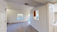 Located in Grandville, Michigan, this two-story home offers 2 bedrooms and 2 bathrooms across two well-proportioned floors. The main level is the larger of the two, featuring an open living area with vaulted ceilings, a ceiling fan, and plush carpeting. Abundant natural light flows in through multiple windows, and a sliding glass door leads directly to an outdoor deck overlooking colorful surroundings. The kitchen is efficiently designed with warm oak cabinetry, light countertops, a double sink, and stainless steel appliances including a range, over-the-range microwave, and refrigerator. Durable wood-look flooring runs throughout the kitchen. Both bathrooms are finished with wood-look flooring, oak vanities, and full tub/shower combos with chrome fixtures. The upper floor houses the bedrooms, including a generously sized primary bedroom with dual closets and vaulted ceilings, providing ample storage. The second bedroom is bright and carpeted, with a large window offering neighborhood views. A hallway and staircase connect the two levels seamlessly. Throughout the home, neutral tones, consistent finishes, and thoughtful layouts create a clean, functional, and inviting living environment.