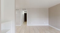 Located at 7511 Beechnut St in Houston, Texas, this single-story, 2-bedroom, 1-bathroom home offers a practical and cohesive layout throughout. Light-toned ceramic tile flooring runs consistently across all rooms, creating a clean, unified aesthetic.

The open living room greets you at the entrance with a large window that brings in natural light, a built-in shelving unit along one wall, and a neutral color palette. It flows directly into the kitchen, which features a peninsula with granite-look countertops, gray cabinetry, black appliances including an electric range and refrigerator, a mosaic tile backsplash, and a window above the sink. An adjacent closet provides convenient pantry storage.

Both bedrooms are comfortably sized, with the primary bedroom offering generous proportions. Each bedroom is equipped with a ceiling fan and light fixture, and windows that provide natural light and outdoor views of surrounding greenery. The hallway connects the bedrooms to the shared bathroom, which includes a tiled tub-and-shower surround with a decorative accent tile border, complemented by white wall tile and tile flooring. Two closets throughout the home offer ample storage. The space maintains a clean, neutral appearance suitable for easy personalization.