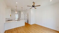 Located at 115 Gaunt Ln in Youngsville, Louisiana, this two-story home offers a clean, modern aesthetic defined by crisp white walls, warm light wood flooring, and an abundance of natural light throughout both levels. The main floor hosts an open-concept kitchen and living area, where the kitchen stands out with white shaker cabinetry, a white quartz peninsula with an integrated sink and gold-toned fixtures, a stainless steel gas range with a wood-accented range hood, a herringbone tile backsplash, and elegant pendant lighting. A glass-paneled door connects the living area to the outdoors, while large windows frame views of the surrounding neighborhood. A half bathroom on the main floor features terrazzo-style tile flooring and a marble-top vanity with brass hardware. Upstairs, light-filled rooms continue the home's airy palette, each equipped with ceiling fans and multi-pane windows that invite natural light and outdoor views. The full bathroom on the upper level is a refined retreat, showcasing floor-to-ceiling marble-look tile in the tub surround, a soaking tub, brass fixtures and sconces, and a white quartz vanity with a gold-framed mirror. A closet and staircase complete the thoughtfully organized layout of this well-appointed home.