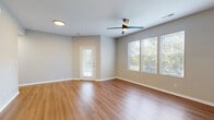 Located at 5555 W 6th St in Lawrence, Kansas, this well-appointed 1-bedroom, 1-bathroom unit offers a thoughtfully designed single-floor layout with a clean, modern aesthetic throughout. The spacious living room greets you with warm hardwood-style flooring, neutral gray walls, a ceiling fan, and multiple windows that invite abundant natural light and views of surrounding greenery. A private entry door adds a welcoming touch to the open, airy feel of the space. The kitchen is a standout feature, showcasing white shaker cabinetry with matte black hardware, sleek quartz-style countertops, a stainless steel sink, and a full suite of stainless steel appliances including a refrigerator, range, microwave, and dishwasher. A breakfast bar provides additional counter space and casual dining options. The bedroom is comfortably sized with plush carpeting, a ceiling fan, and a window overlooking the outdoors. It connects to a generously sized walk-in closet outfitted with wire shelving for efficient organization. Two additional closets provide ample storage throughout the unit. The full bathroom features wood-look flooring, a white vanity with marble-style countertop, matte black fixtures, and a shower-tub combination. A dedicated laundry room with a full-size washer and dryer completes this practical and polished home.