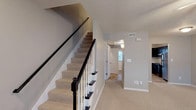 This two-floor Kennedy property offers a practical and well-organized layout across both levels. The main floor is anchored by a spacious living area finished with neutral-toned carpet and a ceiling fan, which flows directly into the kitchen. The kitchen is outfitted with dark espresso cabinetry, light granite-style countertops, stainless steel appliances including a refrigerator, electric range, and dishwasher, as well as tile flooring and a window that brings in natural light. A door off the kitchen provides convenient exterior access.

A staircase with a dark wood railing and carpeted treads connects the two floors, leading to the upper level where the bedrooms are located. Each bedroom features neutral carpet, ceiling fans, and soft gray walls. At least one bedroom includes double bifold closet doors offering generous built-in storage. The bathrooms are clean and functional; one features a tub-shower combination with a curved curtain rod and tile flooring, while a secondary bath includes a single vanity with a large mirror. Throughout the home, consistent neutral tones, white trim, and textured ceilings contribute to a cohesive and move-in-ready atmosphere.