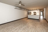 Located at 488 Des Moines St in Des Moines, Iowa, this well-appointed one-bedroom, one-bathroom unit offers a thoughtfully designed open-concept layout. Light wood-style flooring flows consistently throughout the space, complemented by neutral tones and dark baseboards that give the interior a clean, contemporary feel.

The combined kitchen and living area serves as the heart of the unit. The kitchen features white cabinetry extending to the ceiling, a sleek white quartz island with a double-basin stainless steel sink, and a full suite of stainless steel appliances including a refrigerator, electric range, microwave, and dishwasher. Track lighting runs along exposed ductwork overhead, lending an industrial-modern character. A ceiling fan adds comfort to the open living area, which receives natural light through a glass entry door and clerestory windows.

The bedroom offers a comfortable footprint with a built-in closet and exposed ductwork details consistent with the unit's modern aesthetic. The full bathroom includes a white vanity with ample cabinet storage, a mirror, and a tub-shower combination, all finished in clean whites and warm wood-tone flooring.

A dedicated laundry area houses a stacked washer and dryer alongside a water heater, adding everyday convenience to this efficiently designed unit.