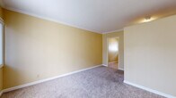 Located at 22027 S Vermont Ave in Torrance, CA, this single-floor, one-bedroom, one-bathroom unit offers a compact and efficiently designed living space. The layout flows from the main living area through a connecting hallway to the bedroom and supporting rooms.

The generously sized bedroom occupies the majority of the unit's footprint, featuring warm golden-yellow walls, white crown molding, and soft wall-to-wall carpeting that adds comfort underfoot. A sliding window allows natural light to filter in, accompanied by a private entry door. The room provides ample space for furnishings and personal use.

The kitchen is thoughtfully appointed with white cabinetry, granite-toned countertops, a double-basin sink, and a gas range with an overhead vent. Tile flooring and a window above the sink provide both practicality and natural light, making the space functional despite its compact footprint.

The bathroom features a tiled shower-tub combination enclosed by a sliding glass door, with a frosted window above for natural light and ventilation. The clean, neutral finishes throughout contribute to a bright and well-maintained feel.

Crown molding is consistent throughout the unit, lending a polished touch to the interiors. The warm color palette, combined with the functional layout and well-maintained finishes, makes this an efficient and comfortable single-level unit in the South Bay area of Los Angeles County.