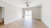 Located at 102 Whistle Stop Cir in Lenoir City, Tennessee, this single-floor, two-bedroom, two-bathroom home offers a clean, modern design with consistent finishes throughout. Light hardwood-style flooring flows seamlessly across all living areas, lending a bright and cohesive feel to the space.

The kitchen serves as a functional centerpiece, featuring white shaker cabinetry, a hexagonal tile backsplash, light granite countertops, and stainless steel appliances including a refrigerator, range, and over-the-range microwave. A center island with a built-in sink and pendant lighting above adds both workspace and visual interest, while crown molding along the ceiling adds a refined touch.

The living area is generously proportioned, with crown molding, a ceiling fan, and a sliding glass door that invites natural light and provides outdoor access. Both bedrooms are well-sized—the primary bedroom is notably spacious—each equipped with a ceiling fan, a window with blinds for natural light, and double closet doors for ample storage.

The two full bathrooms are consistently appointed with light granite vanities, brushed nickel fixtures, and full tub-shower combinations. A dedicated utility room rounds out the home's practical layout. Neutral wall tones and clean finishes throughout create a move-in-ready, contemporary living environment.