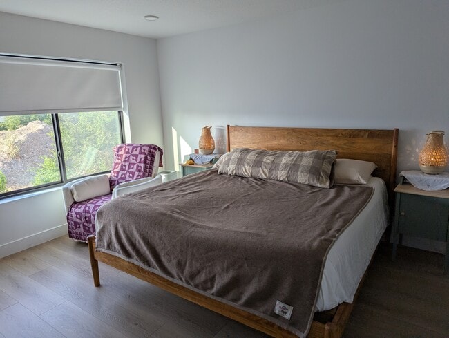 Dormitorio principal con baño privado, pisos de madera e iluminación empotrada. - 44 W Iko Ave