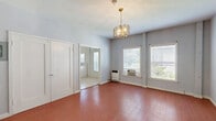 Located at 117 S Isabel St in Glendale, CA, this one-bedroom, one-bathroom unit offers a practical and efficiently designed single-floor layout. The main living area is the most expansive space in the unit, featuring warm hardwood flooring and soft blue-gray walls that create a calm, neutral atmosphere. A decorative gold chandelier serves as a focal point overhead, adding a subtle vintage touch. Natural light filters in through windows, and a wall-mounted heater provides supplemental warmth. A double-door closet is conveniently situated within the main living space, offering generous built-in storage.

The kitchen is finished with light ceramic tile flooring, white cabinetry, an overhead range hood, a gas range, and a stainless steel sink with adjacent counter space. A refrigerator is visible through the open kitchen entry, and a dedicated laundry area is included within the unit.

The full bathroom features tile flooring, a white vanity with countertop sink, a wall mirror, and a shower-tub combination. A window allows natural light into the space. Throughout, the unit maintains a clean, minimalist aesthetic with white trim and neutral wall tones.