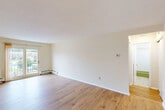 Located at Pheasant Circle in Milford, MA, this one-bedroom, one-bathroom residence offers a thoughtfully organized layout across a single floor. The living room is bright and open, featuring light hardwood flooring, crisp white walls, and large sliding glass doors that flood the space with natural light and provide direct access to a private balcony. The balcony overlooks the landscaped community grounds, offering pleasant views of green lawns and surrounding brick buildings. Baseboard heating runs throughout, ensuring year-round comfort. The open living area flows into a combined dining room and kitchen, creating a practical and connected space for everyday living. The spacious primary bedroom continues the hardwood flooring theme, includes a window for natural light, baseboard heating, and benefits from generous closet storage — with two closets providing ample organizational space. The full bathroom features a tiled tub-shower combination with white subway tile surround, a vanity with integrated sink, and classic chrome fixtures. A dedicated entrance, hallway, and three total closets round out the unit's functional design. The overall aesthetic is clean, neutral, and move-in ready, making this a well-appointed residence in a established community setting.