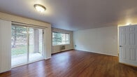 Located at 6614 North Cedar Road in Spokane, WA, this single-floor unit offers a comfortable and functional layout designed for everyday living. Rich wood-style flooring flows throughout the main living areas, creating a warm and cohesive aesthetic. The open living room is bright and welcoming, featuring multiple windows that frame lush outdoor views of the surrounding greenery, as well as a sliding glass door that leads to a private patio — ideal for enjoying the Pacific Northwest scenery. A wall-mounted HVAC unit ensures year-round comfort. The kitchen is well-equipped with rich, dark wood cabinetry, tile backsplash, ample counter space, and black appliances including a refrigerator, range, and dishwasher, all set on light wood-style flooring. The bedroom is a quiet retreat, featuring plush carpeting, a large window overlooking a natural hillside, and access to a closet. The bathroom offers a full tub and shower combination with grab bars for added safety, dark wood vanity cabinetry, and hardwood-style flooring. A dedicated in-unit laundry area with a full-size washer and dryer and overhead shelving adds exceptional convenience. This unit provides a practical and inviting living space in a scenic Spokane neighborhood.