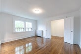 Located at 320 Avenue Rd in Toronto's desirable midtown neighbourhood, this efficiently designed unit makes excellent use of its single-floor layout. The space is composed of a main living area, kitchen, hallway, and bathroom, offering a practical and comfortable floor plan.

The living area is a standout, featuring warm hardwood flooring that extends throughout, crisp white walls, and elegant crown moulding. A classic cast-iron radiator provides character while ensuring reliable heating. Large windows invite generous natural light and frame views of the surrounding mature tree canopy, creating a bright and inviting atmosphere.

The kitchen is thoughtfully appointed with rich dark wood cabinetry, a full suite of stainless steel appliances including a refrigerator, stove, and dishwasher, and a clean tile backsplash. Light-toned floor tiles contrast beautifully with the cabinetry, and track lighting overhead ensures excellent task illumination.

The hallway connects the rooms with ease, while the bathroom offers a clean, all-white aesthetic complete with a tiled shower-tub combination and a frosted window for natural light and privacy. Throughout the unit, white-panelled doors and consistent trim work tie the design together, giving the space a cohesive and well-maintained character.