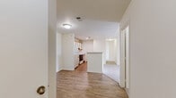 Located at 630 S Peck Dr in Longmont, Colorado, this single-floor residence offers three bedrooms and two full bathrooms in a well-organized, functional layout. The kitchen is a standout feature, equipped with white cabinetry accented by warm wood trim, a double-basin sink, a dishwasher, a coil-burner range, and a full-size refrigerator. A peninsula counter separates the kitchen from the adjacent living area, creating an open flow. A dedicated pantry closet provides additional storage. The living area is carpeted and receives generous natural light through a large sliding glass door that opens to an outdoor balcony, offering pleasant views of the surrounding neighborhood and mature trees. Each of the three bedrooms is finished with plush carpet and features windows that bring in natural light. The spacious primary bedroom includes a vaulted ceiling detail that adds an airy sense of volume. Both bathrooms are cleanly appointed with white vanities, wood-trimmed cabinetry, and bright vanity lighting. One bathroom includes a full tub-shower combination with wood-look flooring, while the second features a mirrored vanity with textured wall finishes. Throughout the home, neutral tones and consistent finishes create a cohesive, move-in-ready atmosphere.