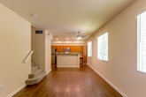 Located at 465 W San Carlos St in San Jose, CA, this two-story, 2-bedroom, 3-bathroom home offers a well-organized layout across two floors. The main level features an open-concept living and dining area bathed in natural light from multiple windows with blinds, complemented by warm hardwood flooring throughout. A ceiling fan adds comfort to the living space. The kitchen is a functional highlight, showcasing stainless steel appliances including a refrigerator, gas range, and microwave, paired with rich wood cabinetry, granite-style countertops, and a central island with a sink — ideal for both cooking and casual dining. A dedicated laundry room with overhead wood cabinetry and washer/dryer hookups adds convenience, and a garage provides secure parking and additional storage. Upstairs, both bedrooms are carpeted and feature neutral tones with natural light from windows overlooking greenery outside. Three closets provide ample storage throughout the home. The three bathrooms include tub/shower combinations with clean, white tile surrounds. A balcony offers an outdoor retreat, while two staircases connect the floors efficiently. The overall ambiance is clean, practical, and well-suited for comfortable urban living in the heart of San Jose.