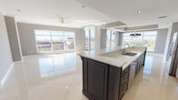 This well-appointed 2-bedroom, 2-bathroom residence is designed with an open, flowing layout across a single floor. The heart of the home is a striking open-concept kitchen and living area finished with large-format polished tile flooring that reflects abundant natural light. The kitchen features a substantial two-tone island with dark navy cabinetry topped with white quartz countertops, complemented by white upper cabinets with glass-front doors and stainless steel appliances. A dramatic multi-arm chandelier adds a decorative focal point to the dining area.

Floor-to-ceiling windows throughout the main living area flood the space with natural light and offer expansive elevated views of the surrounding cityscape and greenery. The living area includes a ceiling fan and tray ceiling detailing, adding architectural depth.

Both bedrooms are generously sized with plush carpeting, ceiling fans, large windows, and ample closet space with built-in shelving. One bedroom provides direct access to a private balcony with a decorative balustrade railing.

The two bathrooms are distinctly appointed: one features marble-surround walls, a soaking tub, and glass enclosure; the other offers a glass-enclosed walk-in shower, vanity, and polished tile flooring. Panel-style interior doors with brushed nickel hardware complete the refined aesthetic throughout.