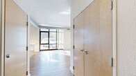 Located at 2401 Chicago Ave in Minneapolis, this two-bedroom, two-bathroom residence offers a well-designed single-floor layout that maximizes functionality and natural light. The open-concept living, dining, and kitchen area serves as the heart of the home, anchored by dramatic floor-to-ceiling windows that flood the space with daylight and provide views of the surrounding neighborhood. Exposed ductwork along the ceiling adds an industrial character to the bright, airy atmosphere.

The kitchen is outfitted with light maple cabinetry, granite countertops, a large center island, and a full suite of stainless steel appliances including a gas range, microwave, dishwasher, and refrigerator. Light wood-style flooring runs through the main living areas, while plush carpet adds comfort to both bedrooms. The primary bedroom is generously sized and features glass-panel doors, while the second bedroom includes a built-in closet. Both bathrooms are finished with wood-tone vinyl flooring and tub-shower combinations. A hallway with in-unit stacked washer and dryer adds everyday convenience. Three closets throughout provide ample storage across this thoughtfully laid-out residence.