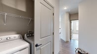 Located at 500 Congaree Rd in Greenville, SC, this well-appointed 2-bedroom, 2-bathroom residence offers a thoughtfully designed single-floor layout with modern finishes throughout. The open-concept kitchen and living area serves as the heart of the home, showcasing white shaker cabinetry, dark countertops, a subway tile backsplash, stainless steel appliances, and a central island with pendant lighting — ideal for both cooking and casual dining. Wide-plank hardwood-style flooring flows seamlessly through the main living areas, adding warmth and continuity to the space. The living room is bathed in natural light through floor-to-ceiling windows and a glass door that opens onto a private balcony overlooking the surrounding Greenville cityscape. Both bedrooms feature plush carpet, ceiling fans, and ample natural light from large windows. The primary bedroom includes a dedicated closet, while both bathrooms are finished with white cabinetry, dark countertops, large framed mirrors, and black hardware accents. One bathroom includes a tub-shower combination with white tile surround. A conveniently placed in-unit laundry closet with full-size washer and dryer hookups rounds out this practical and stylish residence.