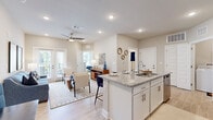 This thoughtfully designed 2-bedroom, 2-bathroom residence offers a comfortable and functional single-floor layout. The open-concept kitchen and living area serves as the heart of the home, featuring white shaker cabinetry, granite countertops, a subway tile backsplash, and a full suite of stainless steel appliances. A spacious kitchen island with seating provides an ideal space for casual dining or entertaining. Light wood-tone flooring flows throughout, complementing the neutral color palette and recessed lighting that brightens the entire space.

The living room is bathed in natural light from French doors that open to an outdoor area, with a ceiling fan adding comfort. Both bedrooms are well-proportioned, each offering ceiling fans, natural light from windows, and easy access to the bathrooms. The primary bathroom includes granite countertops, white cabinetry, and a soaking tub. A dedicated closet provides organized storage, and the in-unit laundry room is equipped with a full-size washer and dryer alongside overhead cabinetry for additional storage. The overall ambiance is clean, bright, and modern, making for a highly livable and inviting residence.