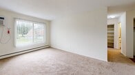 Located at 2210 Skillman Ave E in North St. Paul, Minnesota, this one-bedroom, one-bathroom unit offers a straightforward, single-floor layout designed for comfortable everyday living. The kitchen is efficiently arranged with white cabinetry, a white refrigerator, and an electric range, complemented by durable wood-look flooring that adds a clean, modern touch. A textured ceiling with flush lighting keeps the space bright and practical. The kitchen opens toward the living area, which features soft wall-to-wall carpeting and a large window fitted with vertical blinds, allowing natural light to fill the room while a baseboard heating unit runs along the wall for year-round comfort. The bedroom is a well-proportioned retreat, also carpeted, with a window overlooking greenery outside and a ceiling light fixture. A wide sliding-door closet with mirrored panels provides generous storage and adds a sense of depth to the room. The bathroom is clean and functional, featuring a full tub-shower combination enclosed by white square tiles and chrome fixtures. Two hallways connect the spaces efficiently, contributing to a sensible, easy-to-navigate floor plan. Overall, this unit presents a tidy, well-maintained living space suited for those seeking practical comfort in a residential North St. Paul neighborhood.