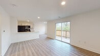 Located at 325 W Parkwood Dr in Dayton, Ohio, this single-floor home has been thoughtfully renovated with modern finishes throughout. The open-concept layout connects the living area and kitchen seamlessly, creating a bright and airy atmosphere enhanced by recessed lighting and light-toned luxury vinyl plank flooring that runs throughout the home.

The kitchen is well-appointed with two-tone cabinetry featuring gold hardware, quartz countertops, a subway tile backsplash, and a full suite of black appliances including a gas range, over-the-range microwave, refrigerator, and dishwasher. A peninsula counter provides additional workspace and casual seating. The living area opens directly to an outdoor deck through a large sliding glass door, bringing in generous natural light and outdoor views of mature trees.

The bedrooms are comfortably sized, each featuring the same consistent flooring. One bedroom includes a ceiling fan with lighting and a window for natural light, while another offers a walk-in closet with built-in rod and shelf storage and its own sliding door to the deck.

Two bathrooms serve the home. The full bathroom showcases large-format marble-look tile on both floors and walls, a soaking tub, and matte black fixtures. The second bathroom features the same elegant tile flooring and a walk-in shower, also finished with matte black hardware accents.
