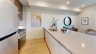 Located at 707 S Berendo St in Los Angeles, this thoughtfully designed one-bedroom, one-bathroom residence offers a clean, modern aesthetic throughout. The open-concept living area seamlessly integrates the kitchen, dining, and living spaces, all finished with light hardwood flooring and crisp white walls that maximize the sense of space and brightness. The kitchen is a standout feature, anchored by a generous quartz waterfall island with bar seating, complemented by warm wood cabinetry, stainless steel appliances including a gas range and built-in microwave, and a tile backsplash. Large sliding glass doors in both the living area and bedroom flood the interior with natural light and provide direct access to a balcony with city views. The bedroom is well-proportioned, offering built-in floor-to-ceiling cabinetry for ample storage and its own balcony-facing slider. The bathroom is elegantly appointed with full marble-style tile walls and floors, a combined soaking tub and shower enclosed by a frameless glass door, and matte black fixtures. Additional conveniences include in-unit laundry, a pantry, and two closets, rounding out this efficiently planned and stylishly finished Los Angeles residence.