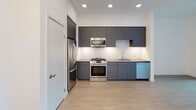 Located on Pacific Avenue in the heart of Long Beach, CA, this single-floor residence offers a thoughtfully designed layout with contemporary finishes throughout. The kitchen is a standout feature, showcasing flat-front charcoal gray cabinetry extending from counter to ceiling, a classic white subway tile backsplash, dark countertops, and a full suite of stainless steel appliances including a gas range, built-in microwave, refrigerator, and dishwasher. Recessed lighting illuminates the space, which flows seamlessly over light wood-style flooring. The bathroom is well-appointed with large-format taupe wall tiles surrounding a soaking tub and shower combination, wood-toned cabinetry, built-in open shelving, and the same warm wood-style flooring that carries through the unit. The bedroom is bright and airy, benefiting from a large window that invites natural light, clean white walls, soft carpet flooring, and a generous sliding-door closet. The overall aesthetic is clean, modern, and cohesive, combining neutral tones with contemporary materials to create a functional and stylish living environment in one of Long Beach's vibrant neighborhoods.