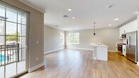 Located at 445 South Ave E in Westfield, NJ, this thoughtfully designed 1-bedroom, 1-bathroom residence offers a well-appointed single-floor layout with generous living space. Light hardwood flooring flows seamlessly throughout, complemented by neutral warm-beige walls and crisp white trim, creating a bright and cohesive aesthetic.

The heart of the home is an expansive open-concept living, dining, and kitchen area filled with natural light from multiple windows that frame lush greenery views. The kitchen features white shaker cabinetry, a large peninsula with white quartz countertops, stainless steel appliances including a refrigerator and microwave, and elegant gold pendant lighting overhead. Sliding glass doors lead to a private balcony, extending the living area outdoors.

The spacious bedroom is a serene retreat with a large window, recessed lighting, and wood flooring. It is accompanied by three well-organized closets with built-in shelving, offering exceptional storage. A dedicated laundry area adds everyday convenience.

The bathroom is finished to a high standard, featuring marble-look tile flooring, a soaking tub with a marble-surround shower, a white vanity with quartz countertop, and a large mirror with bright vanity lighting. Crown molding and recessed lighting throughout add refined architectural detail to this polished Westfield residence.