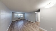 Located at 8 Old Colony Ln in Arlington, MA, this single-floor, 2-bedroom, 1-bathroom residence offers a clean, functional layout with a cohesive design throughout. The living room is the heart of the home, featuring light-toned hardwood-style flooring, neutral gray walls, textured ceilings, and a window unit for climate control alongside baseboard heating. A window allows natural light to fill the space, creating a bright and open feel. The kitchen is efficiently designed with white cabinetry, granite-look countertops, a stainless steel sink, and white appliances including a refrigerator and dishwasher, all complemented by light wood flooring. The primary bedroom is a well-proportioned room benefiting from dual windows that invite abundant natural light and outdoor views, also featuring baseboard heating and the same consistent hardwood-style flooring. The second bedroom is similarly finished with clean walls and matching floors. The bathroom is tiled in neutral tones with a full bathtub with shower, toilet, and a window for natural ventilation. With four closets distributed throughout the unit and a connecting hallway, storage and flow are thoughtfully addressed in this well-maintained Arlington residence.