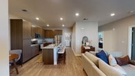 This thoughtfully designed single-floor residence offers a cohesive blend of modern finishes and functional living spaces. The open-concept layout connects the kitchen, dining, and living areas seamlessly, creating a welcoming and spacious atmosphere. The kitchen is a standout feature, equipped with rich dark wood cabinetry, granite countertops, stainless steel appliances including a refrigerator, electric range, and microwave, and a large center island with bar seating — ideal for both meal preparation and casual dining. Light wood-style flooring runs throughout the main living areas, complementing the neutral color palette.

The living room offers a comfortable gathering space anchored by a sleek linear fireplace, a large window allowing natural light to fill the room, and direct sightlines to the outdoors. The bedrooms are carpeted for warmth and comfort, each featuring ceiling fans and windows with blinds. The primary bedroom provides a well-sized retreat, while an additional room offers flexibility as a bedroom or office.

Two bathrooms serve the residence, each finished with granite-topped dark wood vanities and tile flooring. One bathroom features a walk-in shower. A dedicated in-unit laundry room with a full-size washer and dryer adds exceptional convenience, rounding out this well-equipped and thoughtfully appointed home.