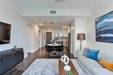 Located in the heart of Atlanta's prestigious Buckhead district, this single-floor residence at 3372 Peachtree Rd NE offers a refined blend of contemporary design and urban sophistication. The open-concept kitchen is a standout feature, outfitted with high-gloss white upper cabinetry, warm wood-tone lower cabinets, a tasteful subway tile backsplash, and a full suite of stainless steel appliances including a French door refrigerator, electric range, built-in microwave, and dishwasher. A large white quartz island with bar seating serves as both a functional workspace and a social hub connecting the kitchen to the dining and living areas. The living room is bathed in natural light from expansive floor-to-ceiling sliding glass doors that open to a balcony, framing sweeping views of the Atlanta skyline and surrounding greenery. Rich hardwood flooring runs throughout the main living spaces, adding warmth to the modern aesthetic. The bedroom offers a tranquil retreat with plush carpeting and tasteful wall art. The bathroom is elegantly appointed with marble-look tile surrounding a deep soaking tub and glass-enclosed shower. Throughout the space, a cohesive palette of neutral tones, modern finishes, and curated design details creates a polished, contemporary atmosphere ideal for upscale urban living.