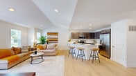 This two-story home offers a thoughtfully designed layout across two levels, with the main living spaces comprising the heart of the home. The open-concept main floor seamlessly connects the living room, dining area, and kitchen, creating an inviting and functional space ideal for both everyday living and entertaining. The living room is bathed in natural light from multiple windows, featuring vaulted ceilings and light-toned hardwood flooring that extends throughout. The kitchen is well-equipped with rich dark cabinetry, white quartz countertops, stainless steel appliances, and a breakfast bar with seating — perfect for casual dining. A dedicated dining area with an elegant light fixture sits adjacent, completing the open layout. Both bathrooms echo the kitchen's design with dark vanity cabinetry and clean white countertops. The generously sized primary bedroom features plush carpeting and a ceiling fan, complemented by its own closet. A dedicated in-unit laundry room adds everyday convenience. The attached garage on the ground level provides secure parking and additional storage. Throughout the home, a neutral palette and modern finishes create a bright, cohesive, and welcoming ambiance.