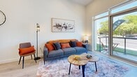Located at 1370 Stittsville Main St in Ottawa, this well-designed single-floor unit offers three bedrooms and two bathrooms within a thoughtfully organized layout. The open-concept kitchen and living area serves as the heart of the home, featuring light hardwood-style flooring throughout, crisp white walls, and impressive ceiling heights that enhance the sense of space. The kitchen is outfitted with full stainless steel appliances — including a French door refrigerator, range, over-the-range microwave, and dishwasher — paired with sleek white cabinetry and a clean-lined countertop. The living area is bathed in natural light from large floor-to-ceiling windows and a sliding glass door that opens to a private balcony with outdoor views of mature trees. The primary bedroom features expansive windows, a double-door closet, and light flooring, creating a bright and restful retreat. An additional bedroom serves well as a home office or guest room. Both bathrooms are finished with elegant marble-effect tile surrounds — one featuring a soaker tub with shower combo, and the other a glass-enclosed walk-in shower — both accented with modern black hardware and grey stone-look tile flooring.