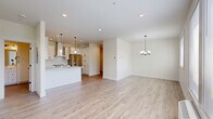 Located at 4885 River Rd N in Keizer, Oregon, this thoughtfully designed one-bedroom, one-bathroom unit offers a clean, modern aesthetic throughout its well-appointed single floor. The open-concept kitchen and living area serves as the heart of the home, showcasing white shaker cabinetry with matte black hardware, striking marble-veined quartz countertops, a farmhouse sink, subway tile backsplash, stainless steel appliances including a range with hood and French door refrigerator, and a central island with pendant lighting. The living and dining area features light luxury vinyl plank flooring, multiple windows that invite natural light and outdoor views, and a stylish chandelier overhead. The spacious bedroom offers soft carpeting, two windows for cross-ventilation and natural light, and easy access to a dedicated closet. The bathroom is finished with wood-look LVP flooring, a marble-veined quartz vanity top, white cabinetry with matte black accents, a framed mirror, and a tiled tub-shower combination. The closet also houses a dedicated water heater. The unit's consistent use of neutral tones, modern fixtures, and quality finishes creates a cohesive, bright, and inviting living environment.