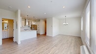 Located at 4885 River Rd N in Keizer, Oregon, this thoughtfully designed one-bedroom, one-bathroom unit offers a clean, modern aesthetic throughout its well-appointed single floor. The open-concept kitchen and living area serves as the heart of the home, showcasing white shaker cabinetry with matte black hardware, striking marble-veined quartz countertops, a farmhouse sink, subway tile backsplash, stainless steel appliances including a range with hood and French door refrigerator, and a central island with pendant lighting. The living and dining area features light luxury vinyl plank flooring, multiple windows that invite natural light and outdoor views, and a stylish chandelier overhead. The spacious bedroom offers soft carpeting, two windows for cross-ventilation and natural light, and easy access to a dedicated closet. The bathroom is finished with wood-look LVP flooring, a marble-veined quartz vanity top, white cabinetry with matte black accents, a framed mirror, and a tiled tub-shower combination. The closet also houses a dedicated water heater. The unit's consistent use of neutral tones, modern fixtures, and quality finishes creates a cohesive, bright, and inviting living environment.