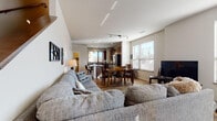 Located at 2902 Harvey St in Madison, Wisconsin, this two-story residence offers a well-designed layout with contemporary finishes across both levels. The main floor centers around an open-concept living, dining, and kitchen area. The living room features warm hardwood-style flooring, recessed and track lighting, and generous windows that invite abundant natural light. The space flows seamlessly into a dedicated dining area and a well-appointed kitchen equipped with dark espresso cabinetry, granite countertops, stainless steel appliances including a gas range, microwave, dishwasher, and refrigerator, along with a large picture window overlooking the exterior. A full bathroom on this level features granite countertops, dark wood cabinetry, and a shower-tub combination. The upper floor hosts additional living space, including a cozy sitting area with corner windows and hardwood-style flooring, as well as multiple bedrooms carpeted for comfort and fitted with large windows that bring in natural light. A second full bathroom mirrors the refined aesthetic of the first, with matching granite countertops and dark cabinetry. A staircase with clean lines connects both floors, contributing to the home's cohesive and modern design throughout.