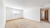 Located at 5284 Seisher Rd in Columbus, Ohio, this single-floor unit offers three bedrooms and two bathrooms across a well-organized layout. The living areas feature neutral-toned wall-to-wall carpeting, clean white walls, and textured ceilings that lend a classic residential feel. Natural light filters through slatted horizontal blinds in each bedroom, keeping the rooms bright and welcoming. The primary bedroom is a comfortable, well-proportioned space with ample room for furnishings, while the additional bedrooms each include closets with wire shelving systems for organized storage. The galley-style kitchen is efficiently designed with warm oak cabinetry, laminate countertops, a double-basin sink, and white appliances including an electric range and refrigerator. Tile flooring runs through the kitchen and bathrooms, providing a durable, easy-to-maintain surface. The two bathrooms include a full bath with a soaking tub and shower combo, and a half bath featuring a single-sink vanity with oak cabinetry and a granite-style countertop. A dedicated laundry area with hookups and overhead shelving adds further convenience. Throughout the unit, warm wood-tone baseboards and trim provide consistent, cohesive detailing.