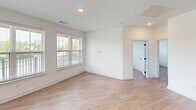 Located at 10 Calm Water Drive in Asheville, NC, this thoughtfully designed residence offers three bedrooms, two bathrooms, and a dedicated closet across a single level. Light wood-style flooring flows throughout, complementing the clean, contemporary aesthetic defined by crisp white walls and black hardware accents.

The kitchen is a standout feature, showcasing gray shaker-style cabinetry that extends to the ceiling, speckled granite countertops, a hexagonal tile backsplash, and a full suite of stainless steel appliances. A peninsula with pendant lighting and an undermount sink provides additional prep space and casual seating.

The open living area benefits from multiple windows dressed with blinds, filling the space with natural light and offering pleasant greenery views. Each bedroom continues this bright, airy character, with large windows — several fitted with ceiling fans — bringing in abundant daylight and outdoor scenery.

The primary bathroom features a walk-in glass-enclosed shower, granite vanity, and direct access to a spacious walk-in closet with built-in shelving. The second bathroom offers a tiled tub-shower combination with a granite-topped vanity and matte black fixtures, consistent with the home's modern design language throughout.