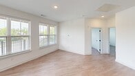 Located at 10 Calm Water Drive in Asheville, NC, this thoughtfully designed residence offers three bedrooms, two bathrooms, and a dedicated closet across a single level. Light wood-style flooring flows throughout, complementing the clean, contemporary aesthetic defined by crisp white walls and black hardware accents.

The kitchen is a standout feature, showcasing gray shaker-style cabinetry that extends to the ceiling, speckled granite countertops, a hexagonal tile backsplash, and a full suite of stainless steel appliances. A peninsula with pendant lighting and an undermount sink provides additional prep space and casual seating.

The open living area benefits from multiple windows dressed with blinds, filling the space with natural light and offering pleasant greenery views. Each bedroom continues this bright, airy character, with large windows — several fitted with ceiling fans — bringing in abundant daylight and outdoor scenery.

The primary bathroom features a walk-in glass-enclosed shower, granite vanity, and direct access to a spacious walk-in closet with built-in shelving. The second bathroom offers a tiled tub-shower combination with a granite-topped vanity and matte black fixtures, consistent with the home's modern design language throughout.