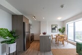Located at 100 Manett Cres in Brampton, Ontario, this thoughtfully designed one-bedroom, one-bathroom unit offers a modern and comfortable living experience across a single floor. Light wood-style flooring flows seamlessly throughout, complementing the bright white walls and clean-lined aesthetic that define the space.

The open-concept living area is a standout feature, bathed in natural light from large windows that frame sweeping panoramic views of the surrounding landscape and city skyline beyond. A secondary living nook provides a versatile retreat, ideal as a reading corner or den. Together, the two living areas offer flexible arrangements to suit various lifestyles.

The bedroom is a serene and spacious haven, featuring a large window with the same impressive outdoor views, roller blinds for privacy, and light wood flooring that adds warmth to the room.

The bathroom is finished with elegant marble-effect wall tiles surrounding a full soaker tub and shower combination, lending a refined, spa-like quality to the space. A dedicated laundry area adds everyday convenience.

The entryway is welcoming and functional, with clean sightlines into the living areas. Throughout the unit, the consistent use of neutral tones, modern fixtures, and abundant natural light creates a bright, airy, and cohesive ambiance.