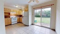 Located at 422 Meadow Dr in Camp Hill, Pennsylvania, this two-floor home offers a practical and comfortable layout suited for everyday living. The kitchen is appointed with light wood cabinetry, a tile backsplash, and white appliances including a range and full-size refrigerator. Easy-care ceramic tile flooring extends throughout the kitchen and adjacent dining area, lending a cohesive and clean aesthetic. A standout feature of the main level is the sliding glass door that floods the space with natural light and provides direct access to a well-maintained backyard, where mature trees and a generous lawn create a serene outdoor setting. A ceiling fan in the dining area enhances comfort and airflow. The neutral, light-toned walls throughout contribute to an open and airy feel. Spanning two floors, the home provides ample room for both living and private spaces, with the upper level offering separation from the main living areas below. Situated in Camp Hill, a quiet and established community in Cumberland County, this property combines suburban tranquility with convenient access to local amenities.