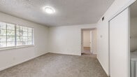 Located at 3529 Robins Landing Way in Decatur, GA, this single-floor, 3-bedroom, 1-bathroom home offers a practical and comfortable layout. The interior is finished with neutral white walls and wall-to-wall carpeting throughout the living and bedroom areas, creating a clean and cohesive aesthetic. Textured ceilings are a consistent design element, and ceiling fans in the bedrooms provide year-round comfort and airflow.

The spacious primary bedroom is the largest of the three, offering generous room to furnish comfortably. The two additional bedrooms each feature carpeted floors, ceiling fans, and natural light from windows with blinds. Sliding closets with built-in rods provide ample storage in the bedrooms.

The kitchen is equipped with white cabinetry, granite-look countertops, a double stainless steel sink, and a black electric range with overhead ventilation. Light wood-look vinyl flooring grounds the kitchen space. The bathroom features full white tile surround in the tub/shower combo, a window for natural light, and a vanity with matching countertop.

A dedicated laundry area with washer and dryer hookups is conveniently integrated into one of the bedroom closet spaces. An accessible electrical panel is also housed within the unit. The hallway connects all rooms efficiently, completing this well-organized home.