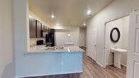 Located at 2811 Oakridge in Lubbock, Texas, this two-story home offers a well-designed layout with modern finishes throughout. The open-concept kitchen serves as the heart of the main floor, showcasing rich dark cabinetry, granite-style countertops, and a large peninsula with a double-basin sink and pendant lighting overhead. Black appliances, including a refrigerator and gas range, complement the kitchen's contemporary aesthetic. Wood-look flooring extends across the main level, lending warmth and continuity to the living areas. Recessed lighting and ceiling fans provide both functionality and comfort throughout the home. A convenient half bath on the main floor features a pedestal sink and an oval decorative mirror, ideal for guests. Upstairs, the bedrooms are finished with plush carpeting and ceiling fans, with windows that invite natural light into each room. The full bathrooms are consistently appointed with granite-topped dark vanities, tub-shower combinations with built-in shelving, and wood-look flooring. The cohesive design palette of neutral tones, dark wood accents, and granite surfaces creates a clean, modern ambiance that flows seamlessly from room to room throughout this well-appointed two-story home.