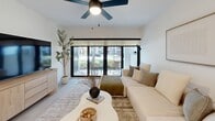 Located at 3101 Village Blvd in West Palm Beach, FL, this thoughtfully designed one-bedroom, one-bathroom residence offers a seamless open-concept layout that connects the living, dining, and kitchen areas into a cohesive, airy space. Light-toned luxury vinyl plank flooring runs throughout, complementing the bright white walls and creating a clean, modern aesthetic.

The kitchen is a standout feature, showcasing a two-tone cabinetry design with warm wood lower cabinets and matte upper cabinets, under-cabinet LED lighting, white quartz countertops, stainless steel appliances, and a central island with pendant lighting and bar seating. The living area is anchored by large sliding glass doors that open to a private patio, allowing natural light to flood the space and offering outdoor access.

The bedroom is a comfortable retreat, featuring a ceiling fan, a window with exterior views, and ample closet storage — with four closets distributed throughout the residence. The bathroom includes a full tub-shower combination, a wood-vanity with a white countertop, and clean tile finishes. A dedicated in-unit laundry room with a full-size washer and dryer adds practical convenience. Ceiling fans in both the living area and bedroom enhance comfort throughout this well-appointed West Palm Beach home.