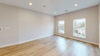 Located at 59 Mill St in Woburn, MA, this thoughtfully designed 3-bedroom, 3-bathroom residence offers a clean, modern aesthetic across a single floor. The open-concept living, dining, and kitchen area serves as the heart of the home, filled with natural light and finished with light hardwood flooring that extends throughout. The kitchen is a standout feature, showcasing white shaker cabinetry, a classic subway tile backsplash, stainless steel appliances, and a striking quartz-topped center island — ideal for both cooking and entertaining. Each of the three bedrooms is generously proportioned with neutral tones and ample closet space; the primary bedroom offers a well-sized layout with its own dedicated storage. With seven closets in total, storage is abundant throughout. The three bathrooms are finished with large-format tile flooring, white subway tile tub surrounds, and brushed gold fixtures, lending a polished and contemporary feel. Additional conveniences include a dedicated laundry room and utility room. Recessed lighting throughout and multiple windows in the bedrooms bring in natural light and outdoor views, enhancing the bright, airy atmosphere of this well-appointed Woburn residence.